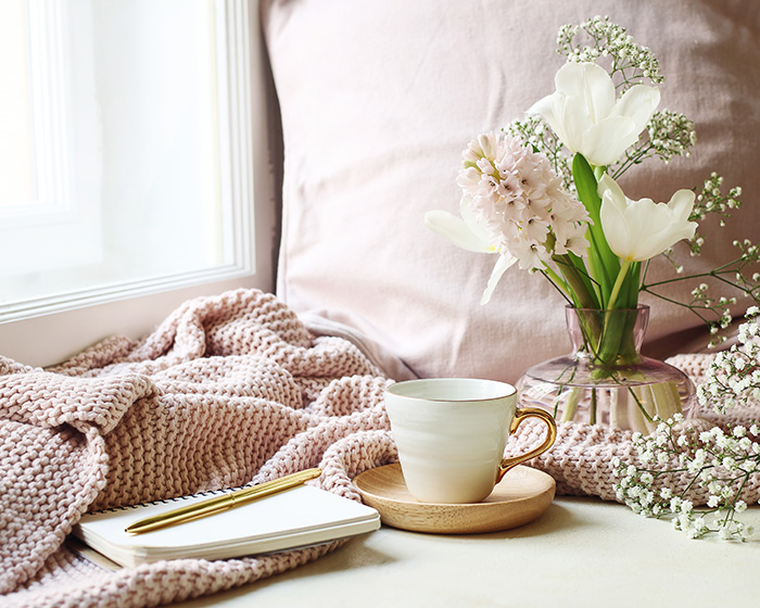 Blanket and cup of tea, journal and flowers with perinatal therapist Christina Rush