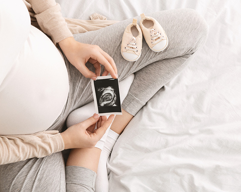 Woman looking at sonogram photo in need of pregnancy support